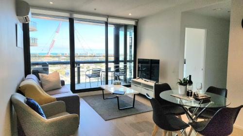 a living room with a couch and a table at Melbourne Lifestyle Apartments - Best Views on Collins in Melbourne