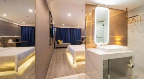 a bedroom with a bed and a sink and a mirror at 7 Days Inn Huizhou Daya Bay Wanda Plaza in Huizhou
