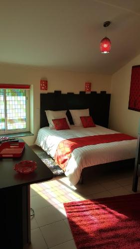 a bedroom with two beds with red pillows and a desk at Chambre D´hôtes Léonie & Restaurant in Druillat