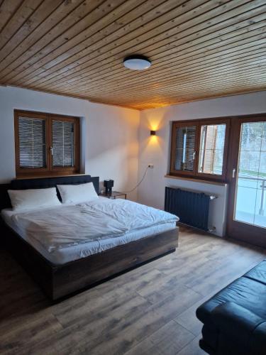 a bedroom with a large bed with a wooden ceiling at Zum schwarzen Hirsch in Dalaas