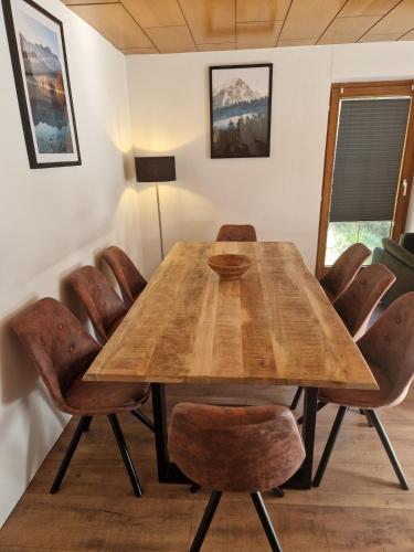 a dining room with a wooden table and chairs at Zum schwarzen Hirsch in Dalaas