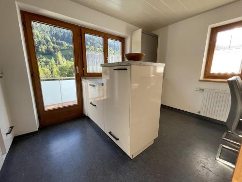 an empty room with a refrigerator and a window at Zum schwarzen Hirsch in Dalaas