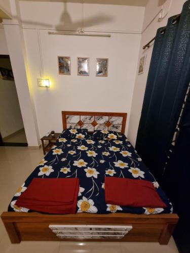 a bedroom with a bed with a blue and white comforter at Krupasindhu Homestay Ratnagiri in Hatkamba