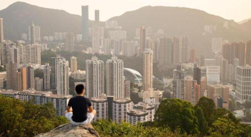 a man sitting on a rock overlooking a city at SLEEEP HKG Causeway Bay in Hong Kong