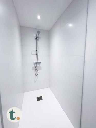 une salle de bain blanche avec douche et toilettes dans l'établissement Tranquiloue - Petite Maison à 10 min du PuyduFou, aux Herbiers