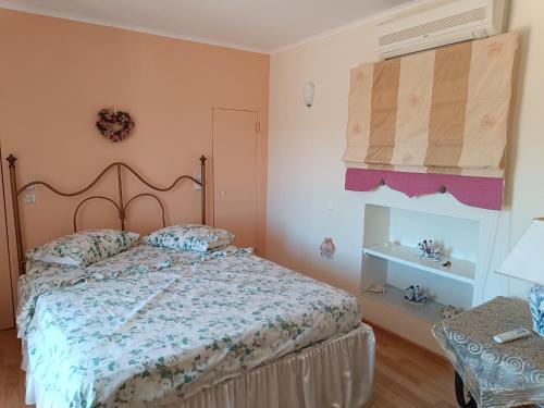 a bedroom with a bed with a floral bedspread at KTHMA "Ν" Πέτρινη Μεζονέτα in Ververáton