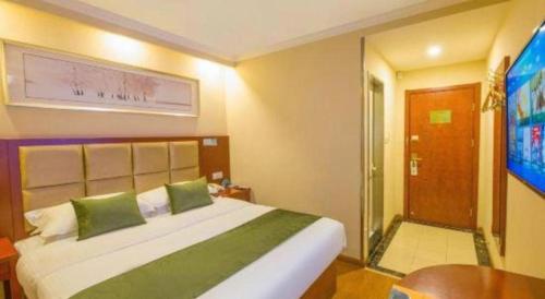 a bedroom with a large bed and a sliding glass door at GreenTree Inn Suzhou Guanqian Street Leqiao Metro Station in Suzhou