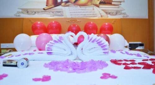 a table topped with pink flowers and red hearts at Vienna Hotel Shenzhen Bao'an Airport Taoyuanju Pingluanshan Metro Station in Shenzhen