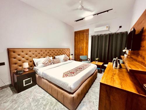 a hotel room with a bed and a television at Hotel Aura Residency , Haridwar in Haridwār