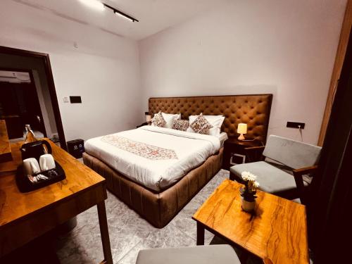 a hotel room with a bed and a chair at Hotel Aura Residency , Haridwar in Haridwār