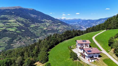 a house on a green hill with a road at Agriturismo Ferienhof Gschloier - Adults only in Laion