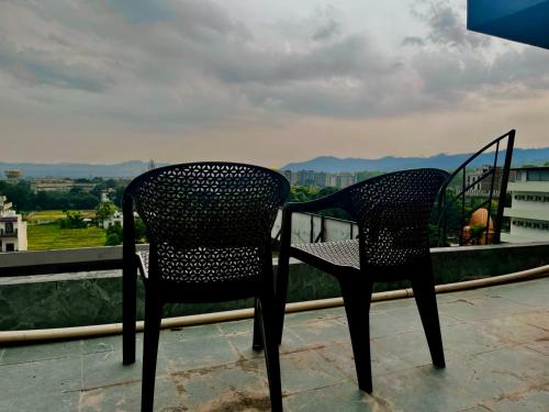 two chairs sitting on top of a balcony at Hotel Aura Residency , Haridwar in Haridwār