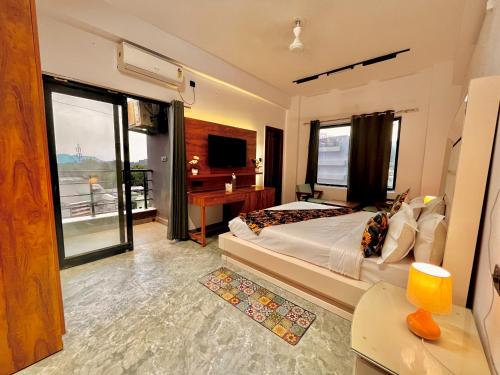 a bedroom with a large bed and a television at Hotel Aura Residency , Haridwar in Haridwār