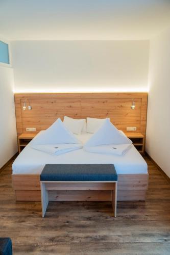 a bedroom with a large bed with a wooden headboard at Hotel Alpina in Kleinarl