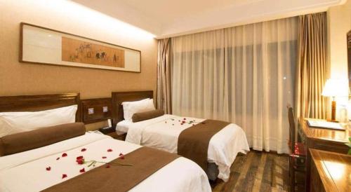 a hotel room with two beds with roses on them at James Joyce Coffetel Xian Dayanta Metro Station Branch in Xi'an