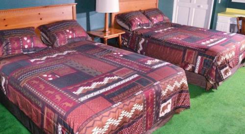 two beds sitting in a room with green carpet at Birchwood Inn in Harbor Springs