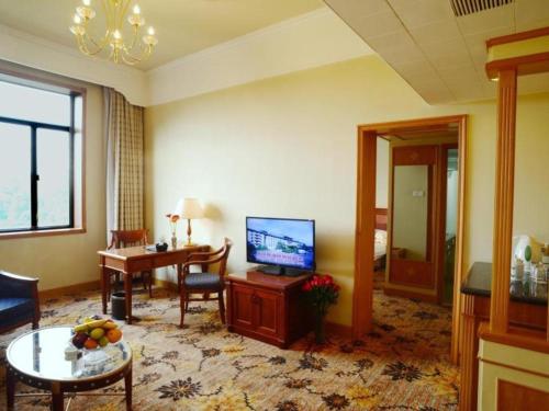 a living room with a television and a table at Beijing Friendship Hotel Jing Bin Building in Beijing
