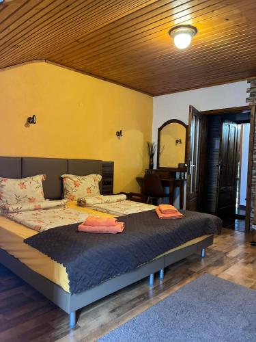 a bedroom with a large bed with a yellow wall at Complex Popangelov in Borovets