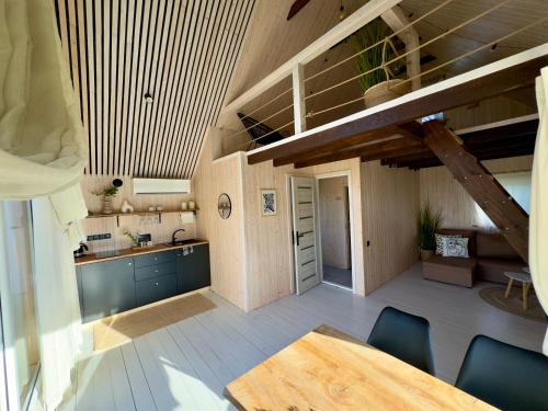 a kitchen and dining room with a wooden ceiling at Sunset Village in Aglona