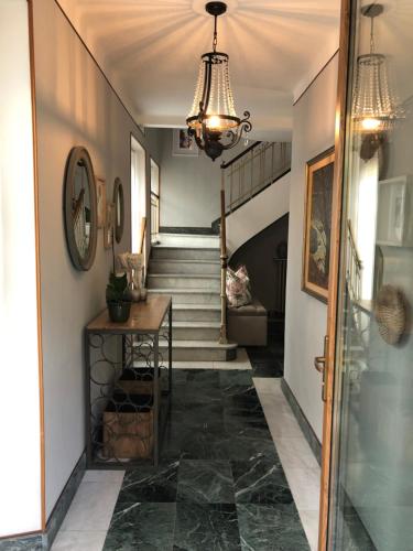 a hallway with stairs and a chandelier at La Casa Verde B&B in Trivero