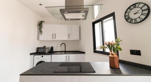 a kitchen with a sink and a clock on the wall at Mi Casa Es Su Casa Nº4 in Albufeira