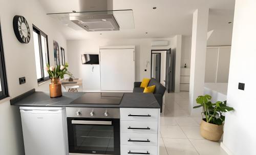 a kitchen with a black counter top and a living room at Mi Casa Es Su Casa Nº4 in Albufeira