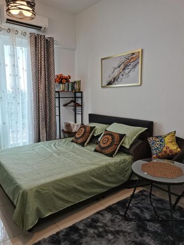 a bedroom with a green bed and a table at BangiSky Homestay, Quite, Strategic & Convinient in Bandar Baru Bangi