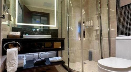 a bathroom with a glass shower and a toilet at Chengdu Haotian Guotai Hotel in Chengdu