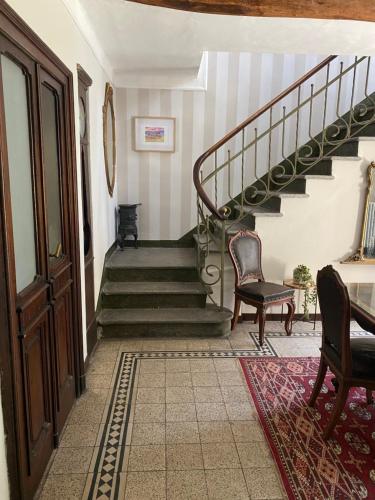 a hallway with a staircase with chairs and a table at La Casa Verde B&B in Trivero