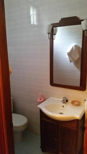 a bathroom with a sink and a toilet and a mirror at Hidalgo in Alcaudete