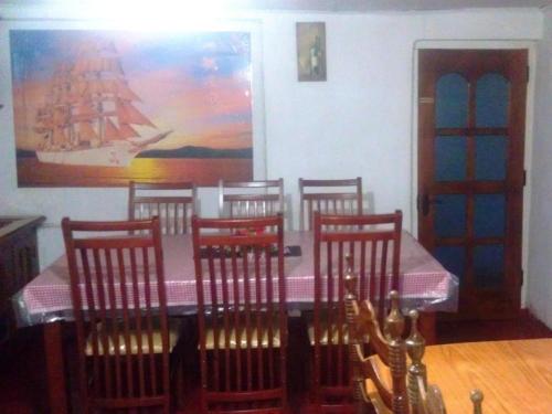 a dining room with a table and chairs and a painting at St. Andrews Hostel in Nuwara Eliya