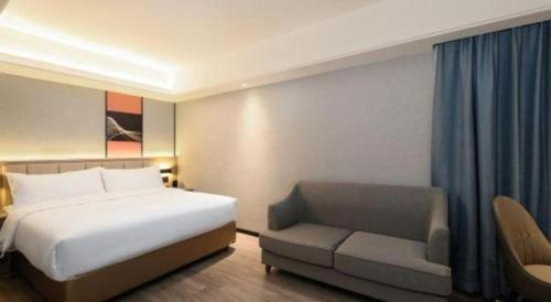 a hotel room with a bed and a chair at Nanning Prince Hotel in Nanning