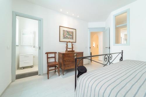a bedroom with a bed and a desk and a window at Casa Nova in Alghero