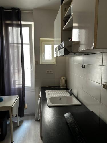 eine kleine Küche mit Spüle und Fenster in der Unterkunft Studio centre ville in La Celle-sous-Gouzon