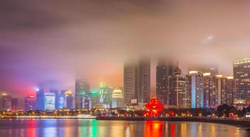 a city skyline with a foggy city at night at 7 Days Inn Qingdao Liaoyang West Road Xinye Plaza Metro Station in Qingdao