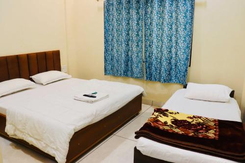 a bedroom with two beds and a window at Hotel Rewanchal in Godarpura