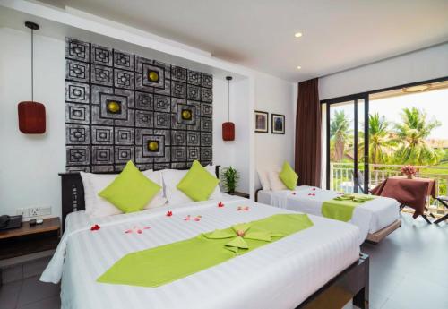 a bedroom with two beds and a balcony at Angkor Home 27 in Phumĭ Réach Born