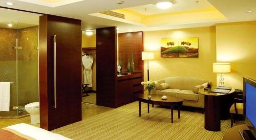 a living room with a couch and a table in a bathroom at Dalian Liangyun Hotel in Dalian