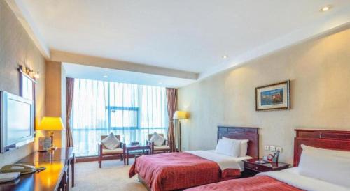 a hotel room with two beds and a large window at Datong Tiangui International Hotel in Datong