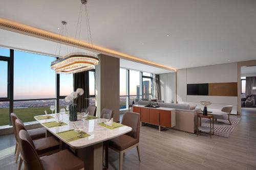 a dining room and living room with a table and chairs at Wanda Jin Xiaohe Xincheng in Taiyuan