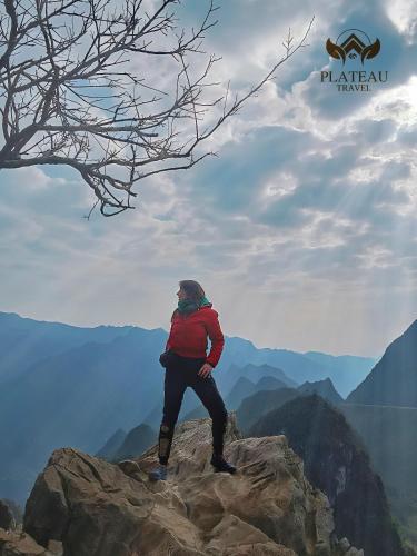 a man standing on top of a mountain at Ha Giang Plateau Travel - Tours & Motorbikes Rental - Cao Nguyen Hotel in Ha Giang