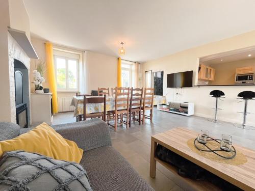a living room with a couch and a table at Maison Confortable Proche des Plages in Fleury