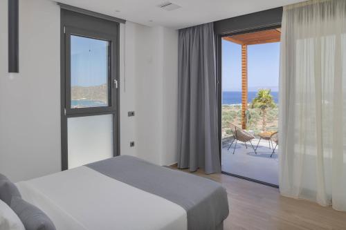 a bedroom with a bed and a view of the ocean at Zeus Luxury Villas in Elounda