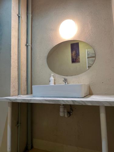 a bathroom sink with a round mirror above it at Sands Dom Szteklin in Szteklin