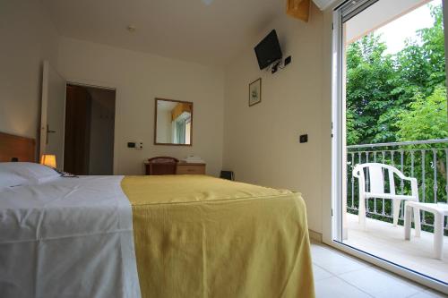a bedroom with a bed and a balcony with a sliding glass door at Hotel Miramare in Forte dei Marmi