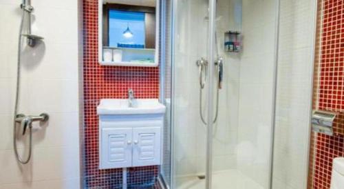 a bathroom with a shower and a sink and a mirror at Metroplace Olympic in Hong Kong