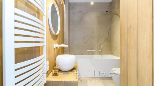 łazienka z białą wanną i umywalką w obiekcie Prestige Apartments Botanica w Gdańsku