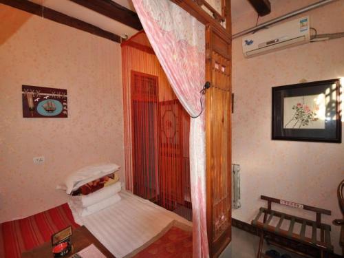 a room with a bird cage in the corner of a room at Pingyao Yufengheng Hotel in Pingyao