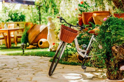 a bike with a basket parked in a garden at Cunda Esen Hotel in Ayvalık
