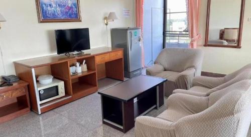 a living room with two chairs and a television at Hihotel Saraburi in Sara Buri